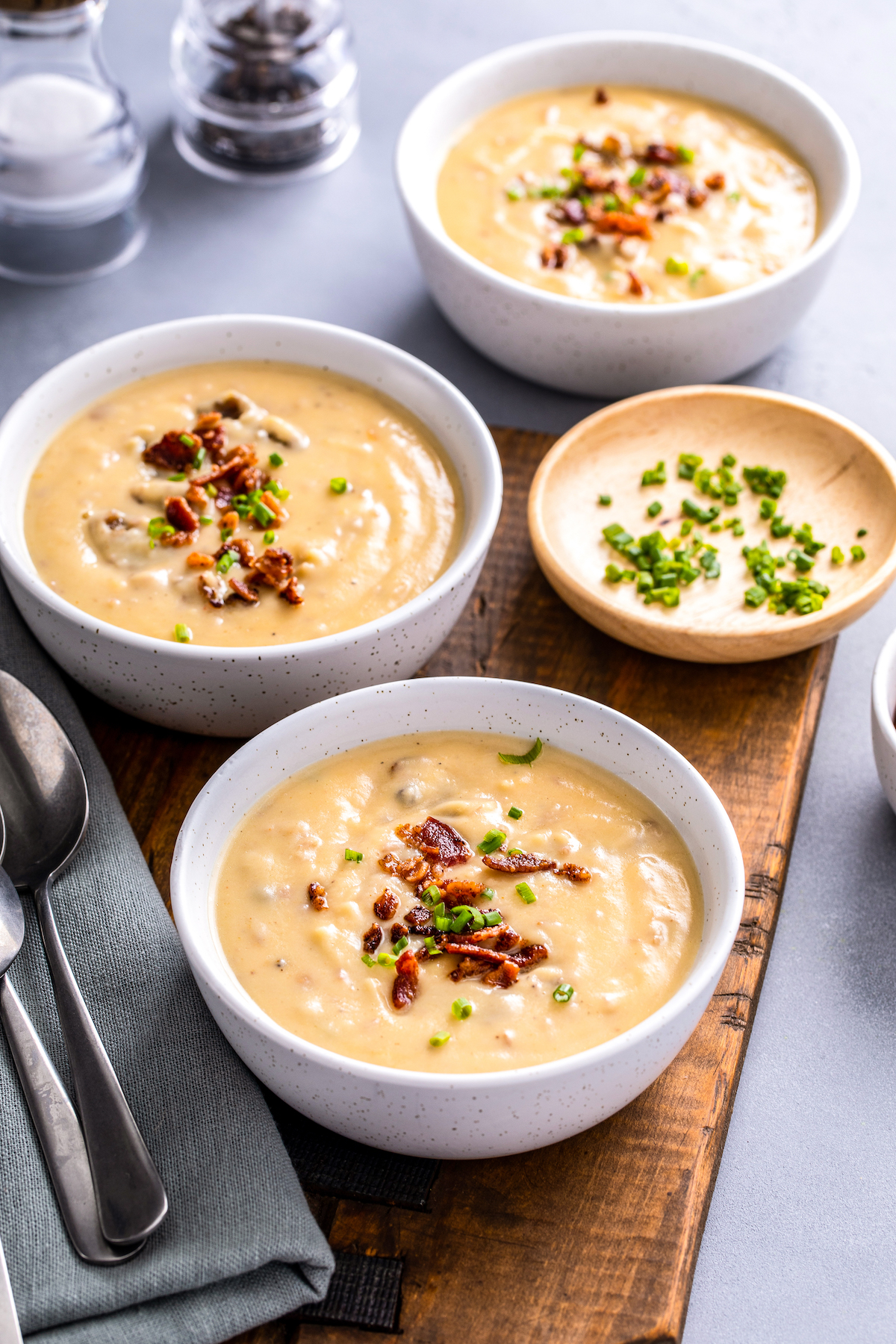 Three bowls of creamy soup on a table, along with