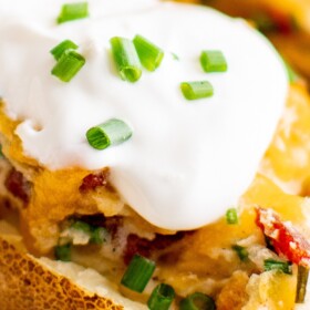 Twice baked potato with sour cream and bacon on top.