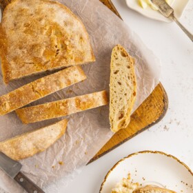 Sliced ciabatta bread with butter on the side.