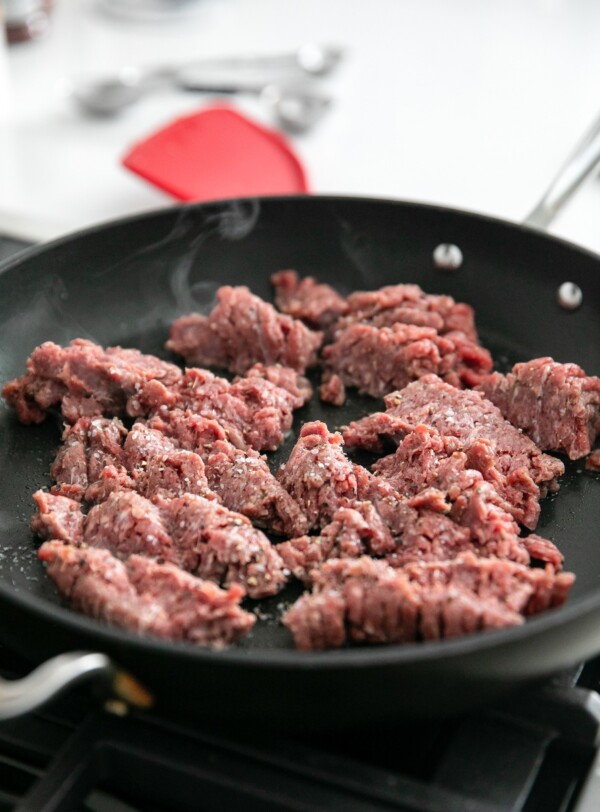 Ground beef cooking in a skillet.