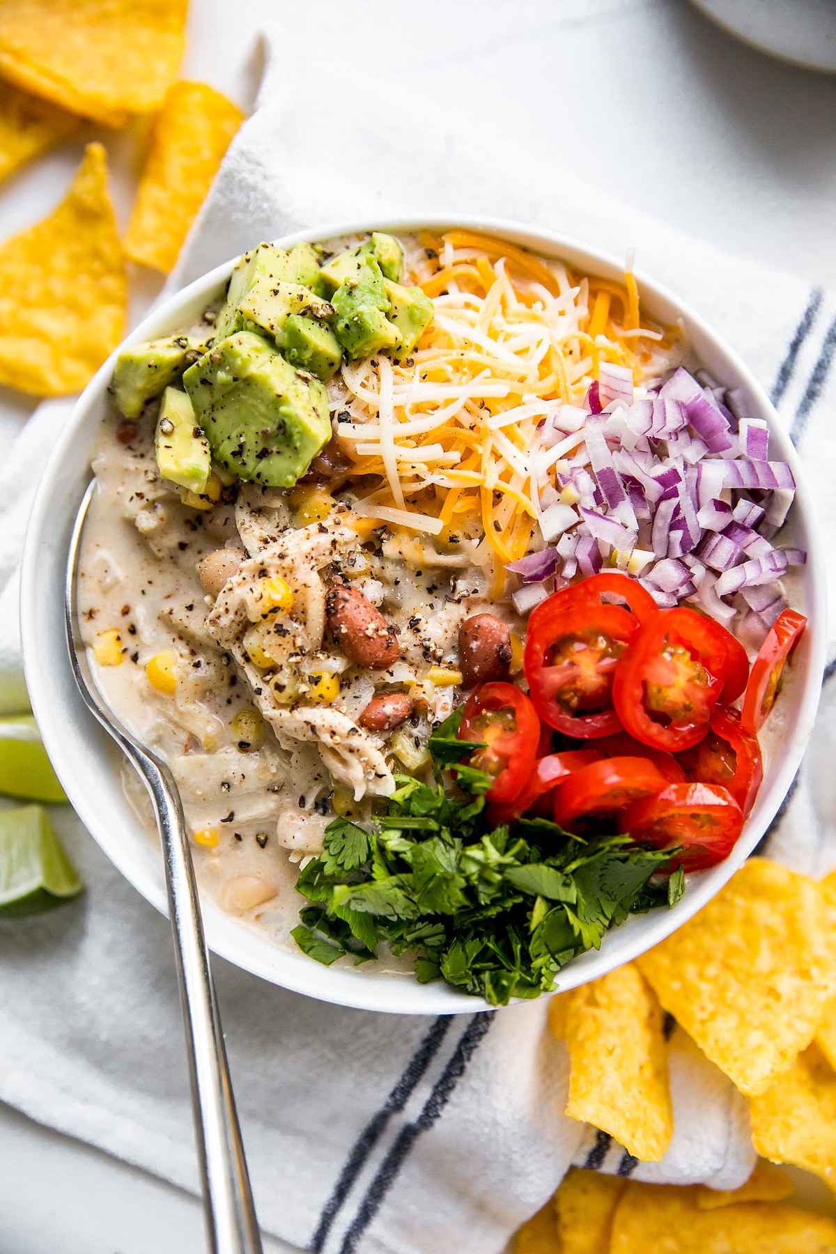 A large bowl of white chili with toppings.