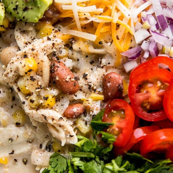 Close-up shot of white chili with several toppings.