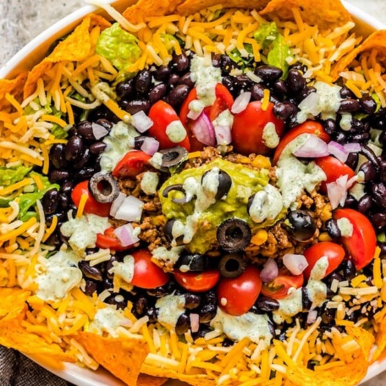 Dorito Taco Salad with dressing and cheese on top.