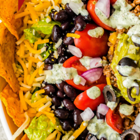 Doritos around the edges of a taco salad in a large serving bowl.