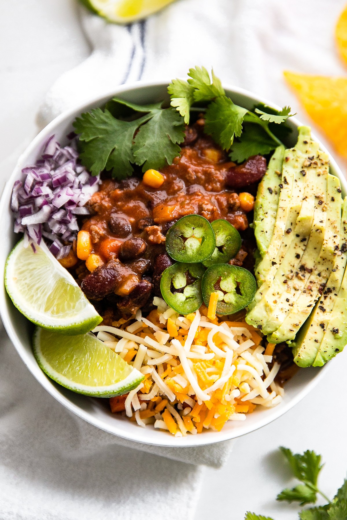 A bowl of homemade chili loaded with toppings.