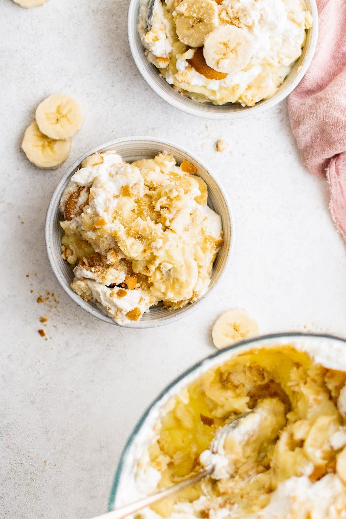 Overhead shot of banana dessert in small bowls next to a larger serving dish.