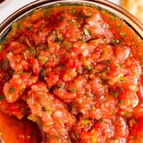 A jar of homemade restaurant style salsa with cilantro.