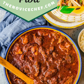 Cochinita Pibil in a large bowl with all the toppings around it for tacos.