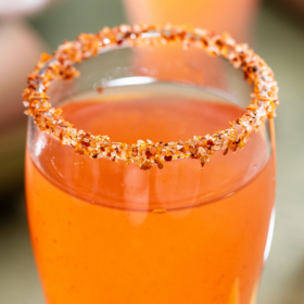 Mexican Candy Shot in a shot glass with a tajin rim.