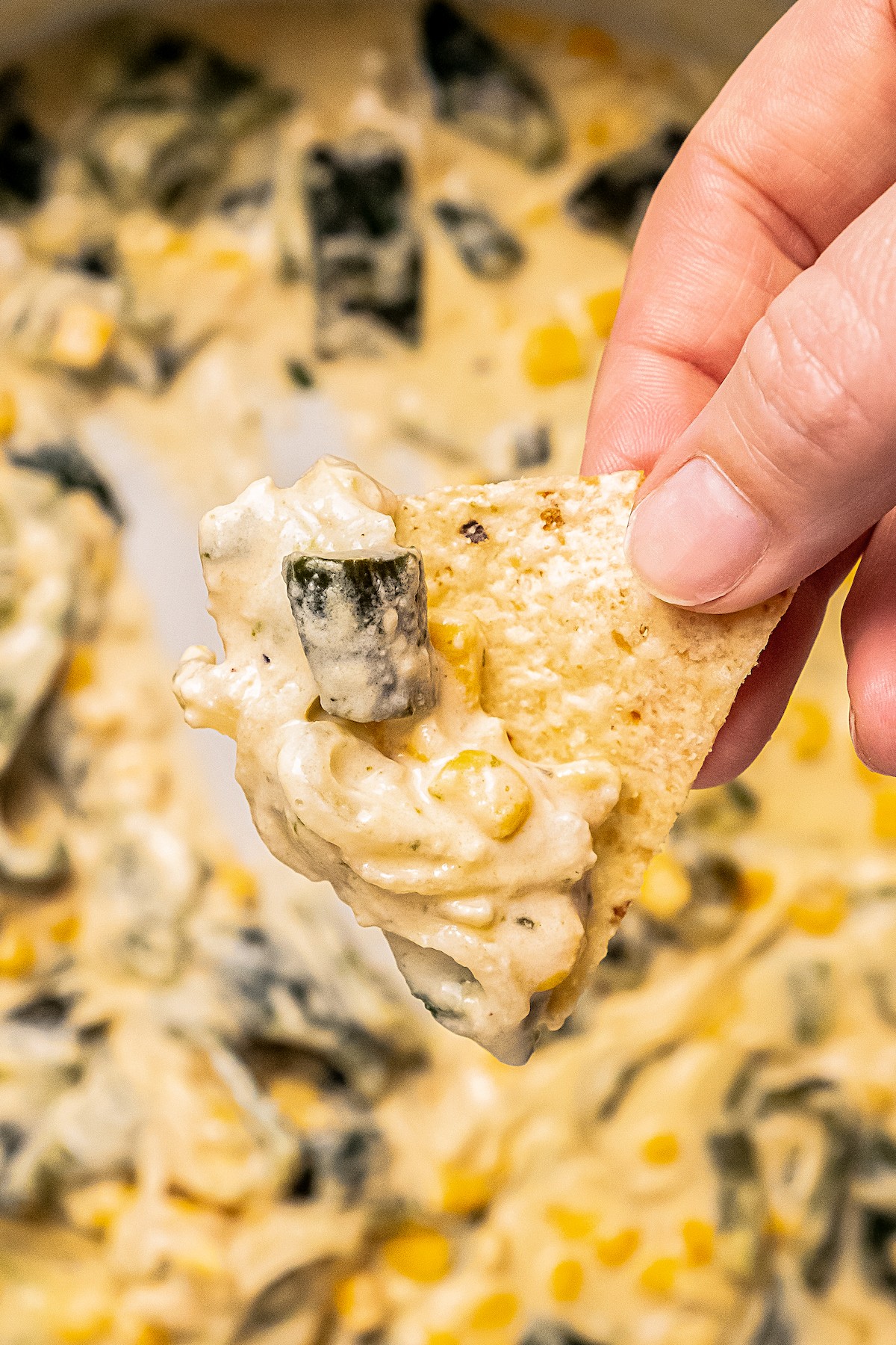 Close-up of rajas on a corn chip. 