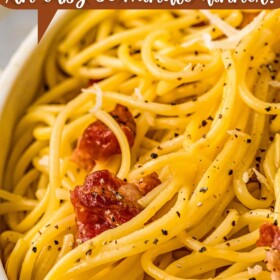 A bowl of Spaghetti Carbonara with black pepper on top.
