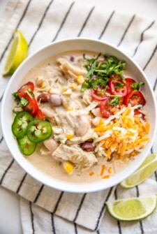 A bowl of white chili with jalapenos and other toppings.