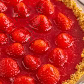 Strawberry pie with a pretzel crust on a cooling rack.