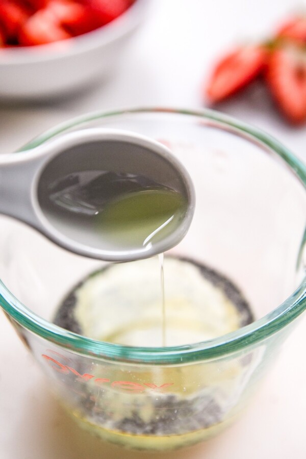 Combining dressing ingredients in a measuring cup.