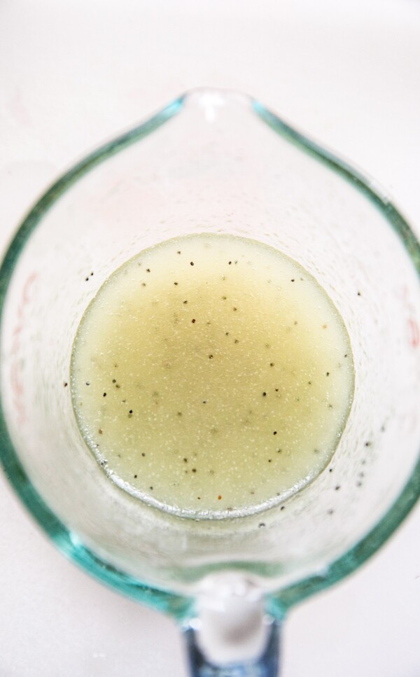 Poppy seed dressing in a measuring cup.