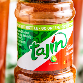 A bottle of tajin with the cap removed off the top of the bottle.
