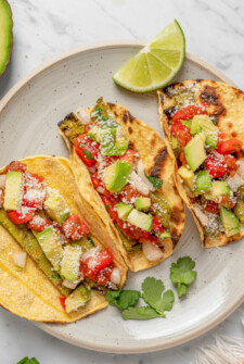 Three nopales tacos with toppings on a plate.