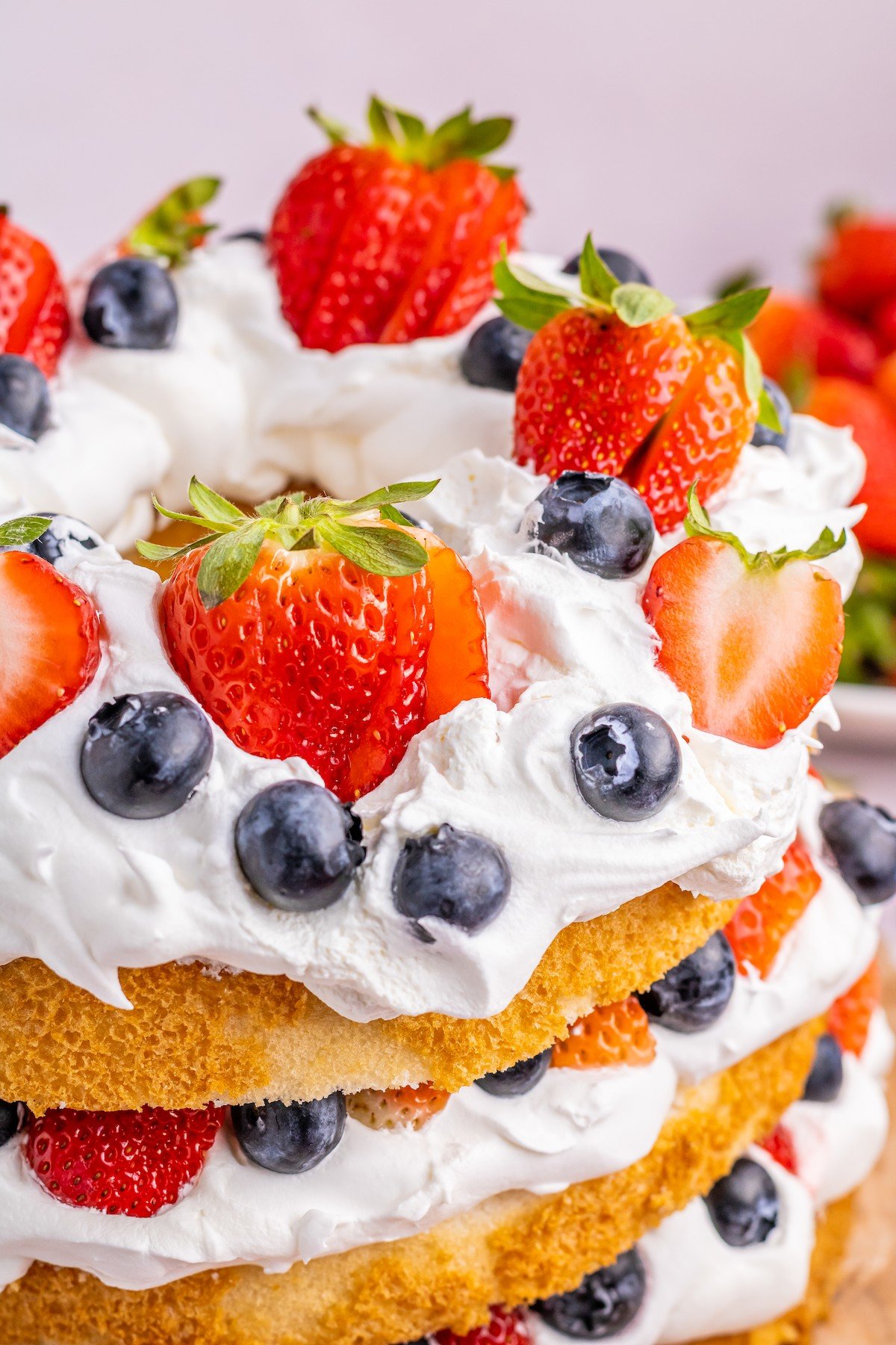 Close-up of blueberries and sliced strawberries on top of a cake.