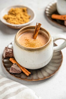A mug filled with Chocolate Atole with a cinnamon stick.