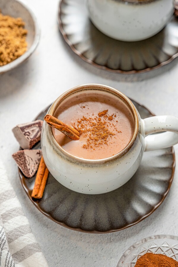 Chocolate Atole in a mug with cinnamon sticks.