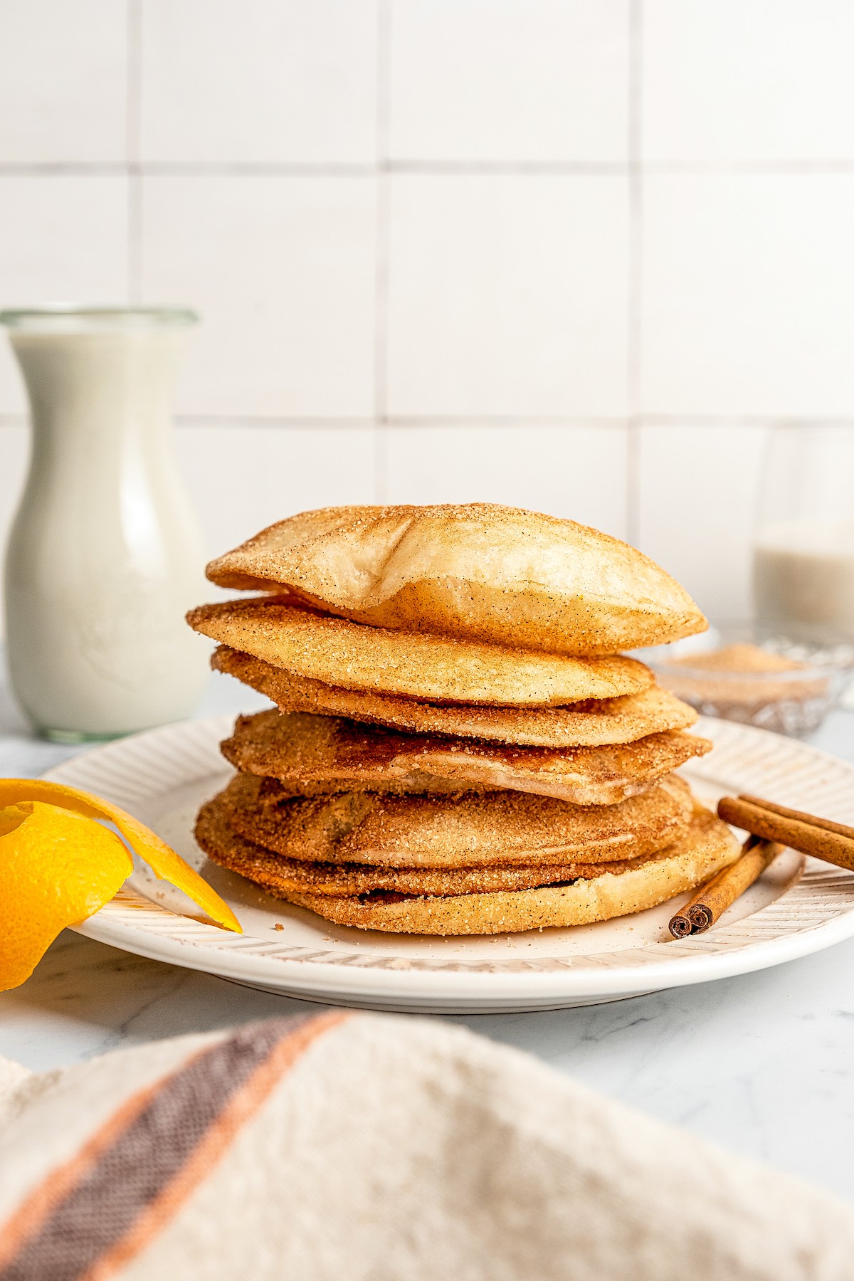 Buñuelos stacked on top of each other on a plate.