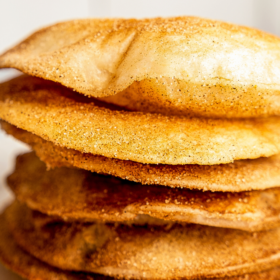 Buñuelos stacked on top of each other on a plate.