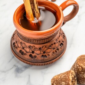 Café de Olla in a clay coffee mug with a cinnamon sitck.