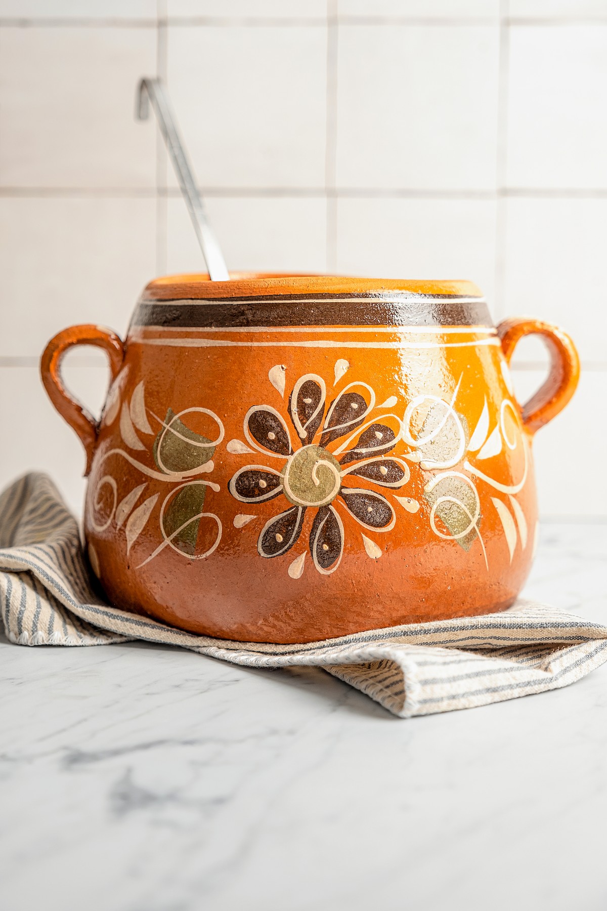 Mexican olla de barro with a ladle inside for serving.