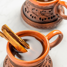 Two cups of cinnamon mexican coffee in clay mugs.