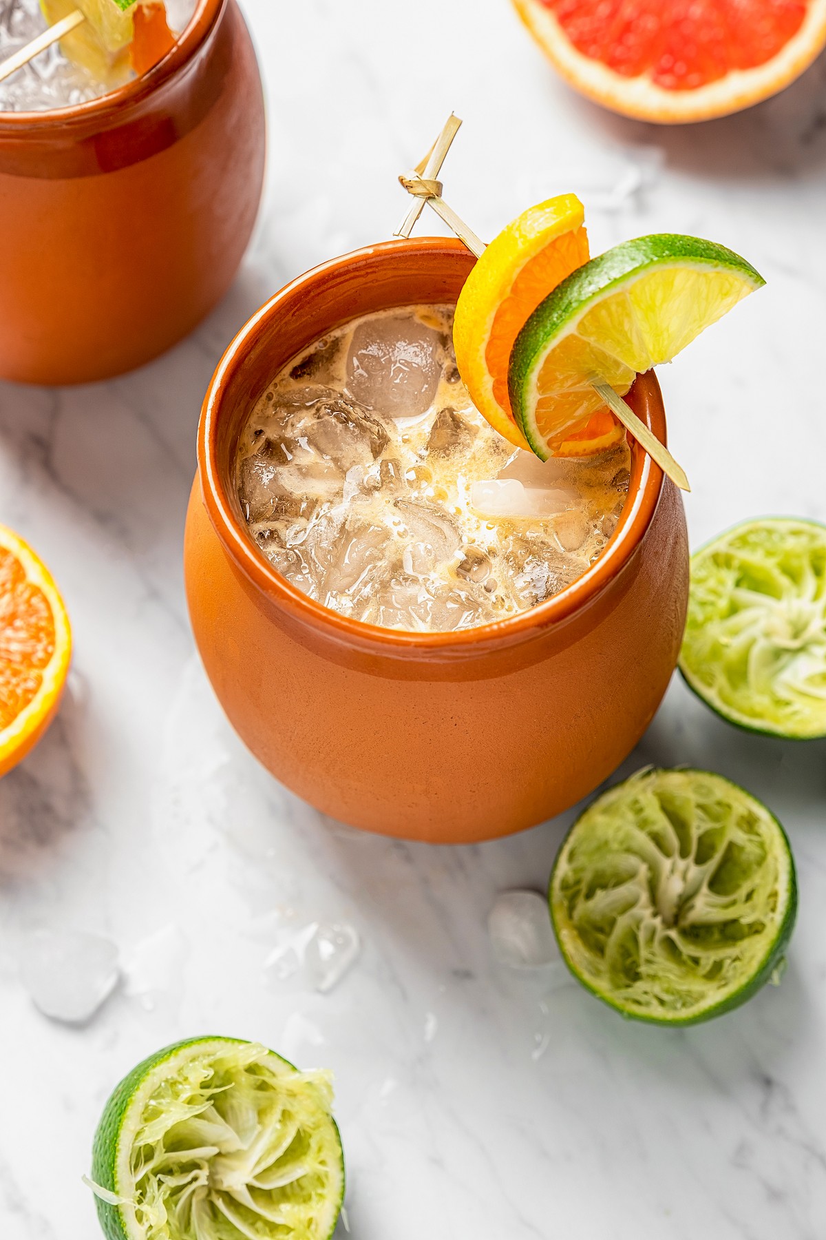 Cantaritos in a Mexican clay mug with fresh citrus around it.