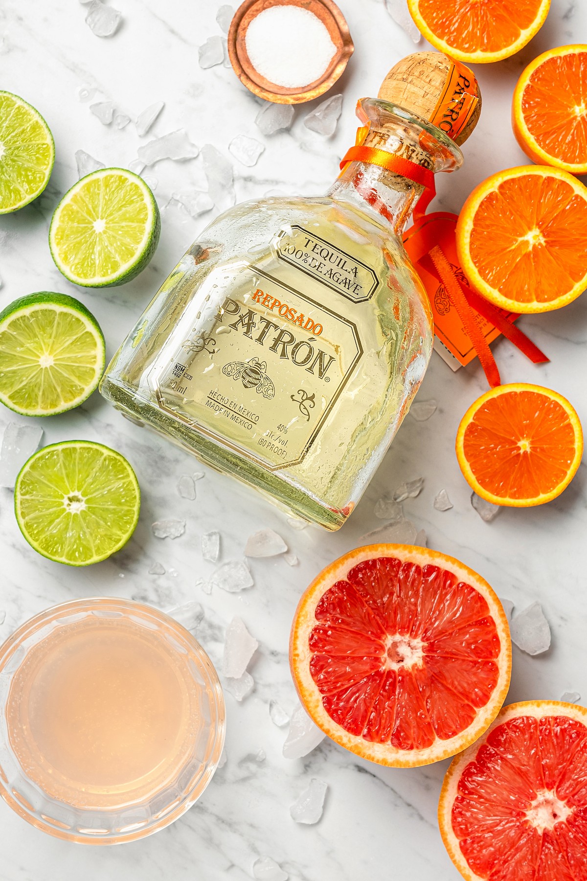 Tequila with fresh citrus rounds and a glass bowl filled with grapefruit soda.