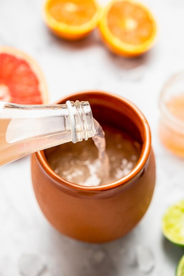 Grapefruit soda being poured into a Mexican clay mug.