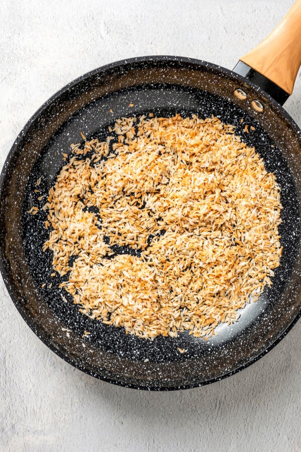 Toasted shredded coconut in a skillet.