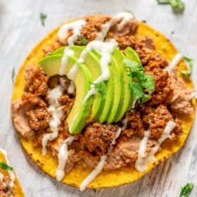 Carne molida tostadas with refried beans, avocado, and crema.