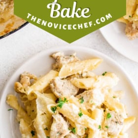 A fork taking a bite of chicken alfredo bake off a plate.