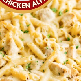A large skillet filled with Chicken Alfredo Bake with fresh herbs on top.