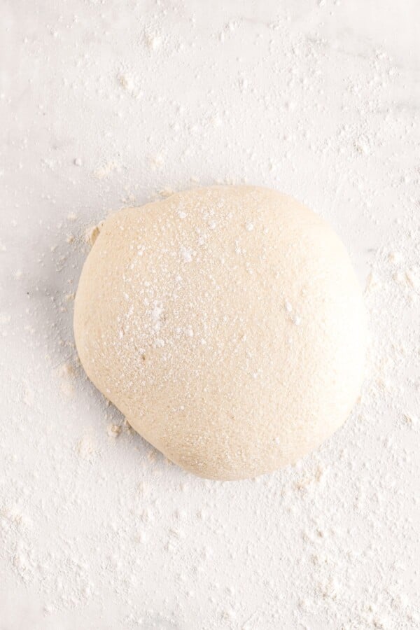 A batch of dough turned out on a lightly-floured surface.