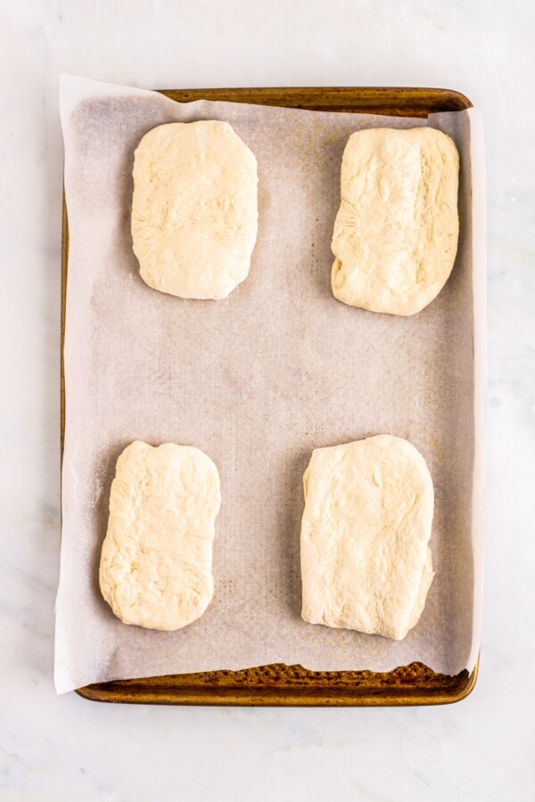 Pieces of dough on a baking sheet lined with parchment.