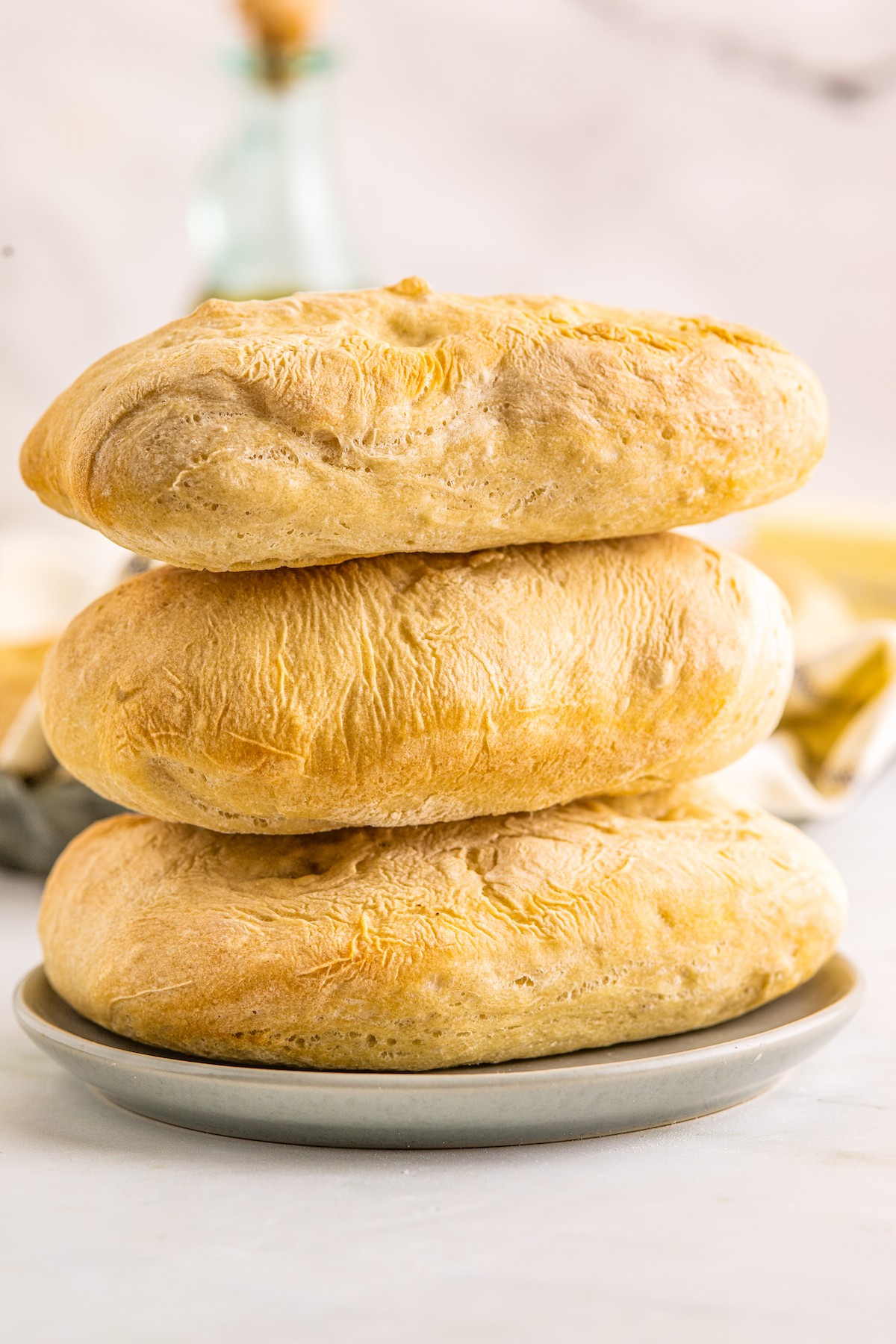 Three ciabatta rolls stacked on top of each other.
