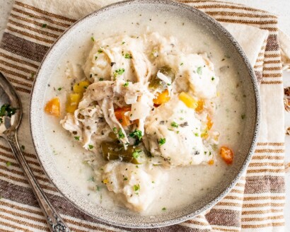 A bowl of slow cooker chicken and dumplings on a cloth napkin.