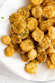 Crispy fried pickles on a white plate.
