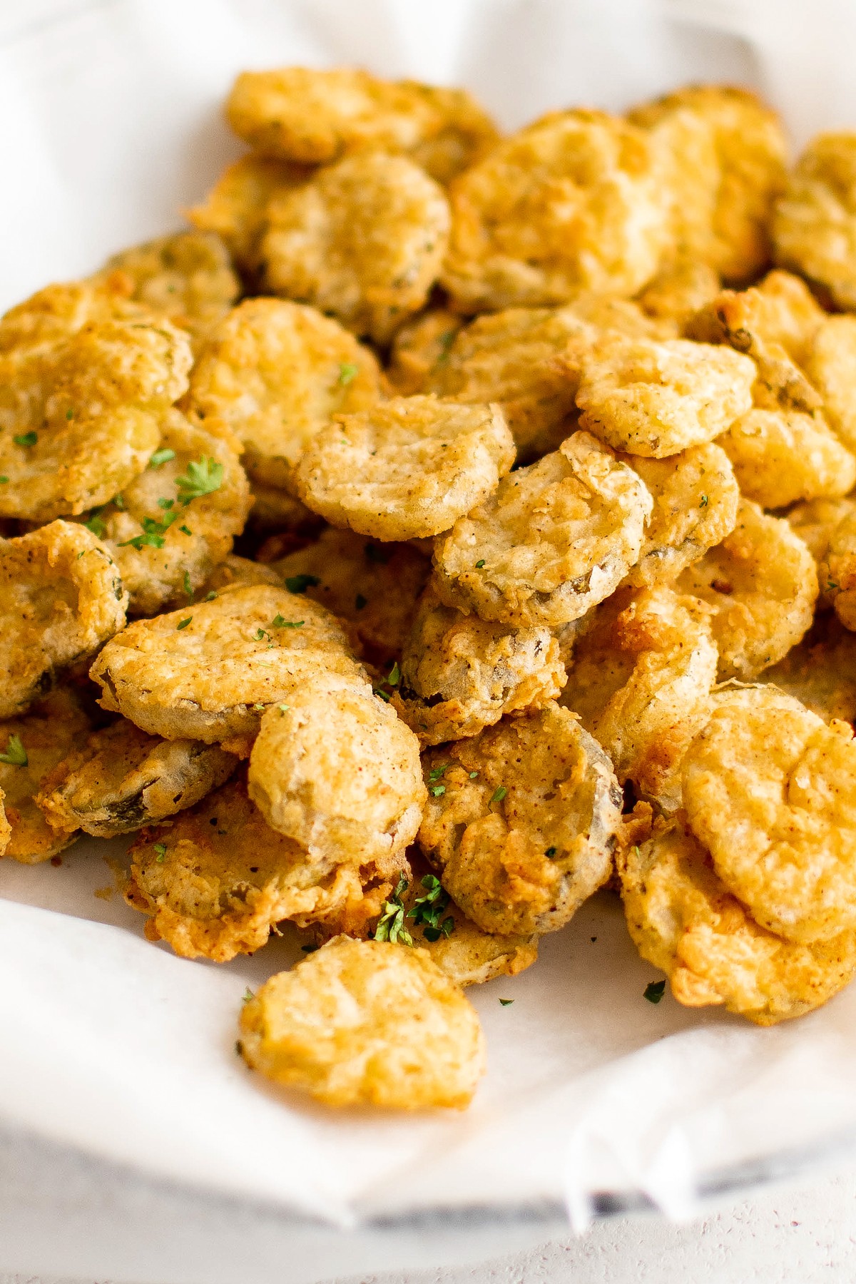 Homemade fried pickles in a white dish.