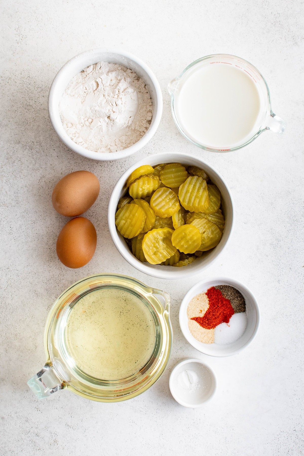 From top: Flour, milk, eggs, dill pickle chips, oil, seasonings, baking powder.