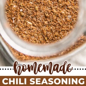 A jar of chili seasoning and individual spices lined up on a counter top.