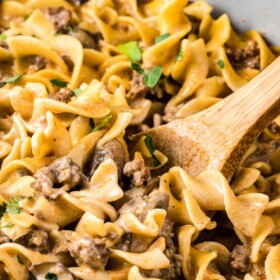 Ground Beef Stroganoff in a skillet with a wooden spoon.