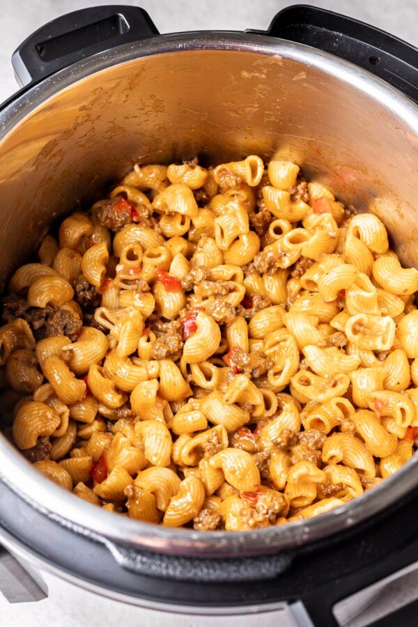 A pressure cooker with cheesy pasta and beef.