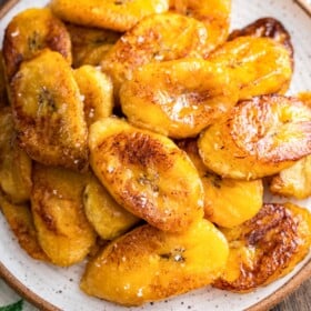 A plate filled with Maduros, sweet plantains, with sea salt sprinkled on top.