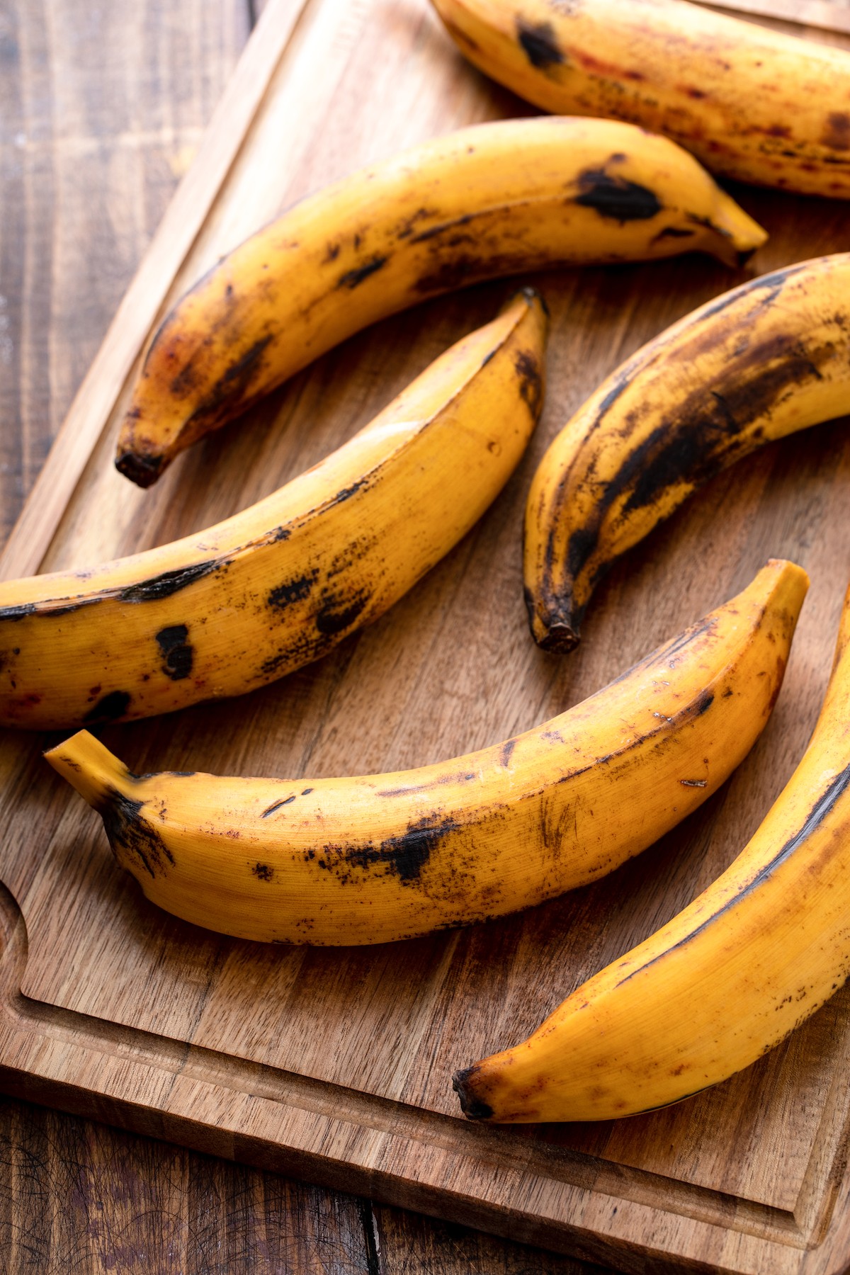 Ripe plantains on a cutting board.