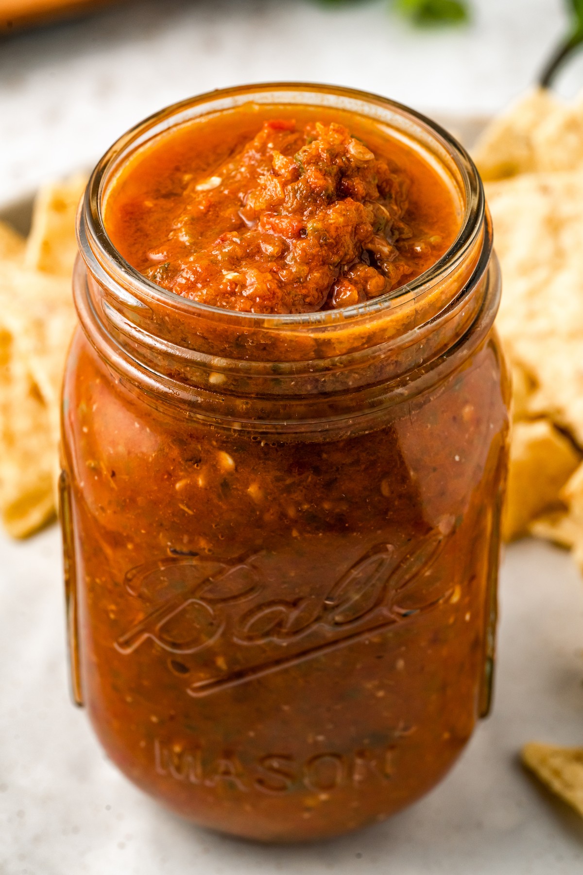 Close-up of salsa in a glass jar. 