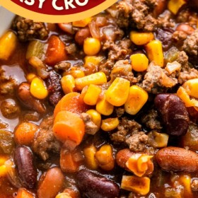 A bowl of slow cooker beef chili with a spoon.